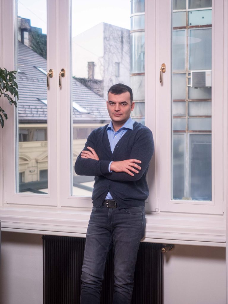 Profesionalno fotografisanje menadžmenta kompanije Inobacka u njihovim kancelarijama u Novom Sadu 2024. godine.  Na slici je muškarac u elegantnom poslovnom odelu, stojeći pored prozora.  Dobro osvetljenje i fokus na detalje čine sliku profesionalnom i atraktivnom.  Idealno za korporativnu prezentaciju i promociju kompanije.