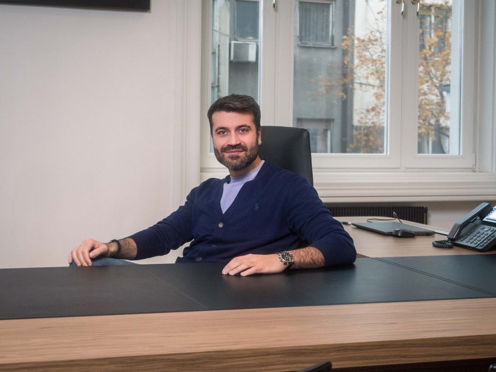 Na fotografiji je član menadžmenta kompanije Inobacka, u Novom Sadu, 2024. godine. Fotografisan je u kancelarijama kompanije.  Muškarac sedi za radnim stolom, obučen u tamnoplavu jaknu.  Ambijent je moderan i profesionalan, sa elementima koji ukazuju na uspešnu i dinamičnu kompaniju.  Fotografija je profesionalno osvetljena i fokusirana, što čini idealnu sliku za korporativnu prezentaciju.